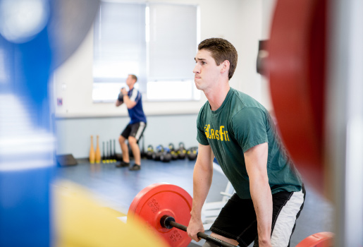 Student lifting weights in the 健康中心.