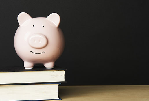 Piggy bank on top of books.