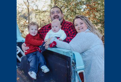 A family of four smiles at the camera